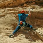 A man climbing up the side of a mountain