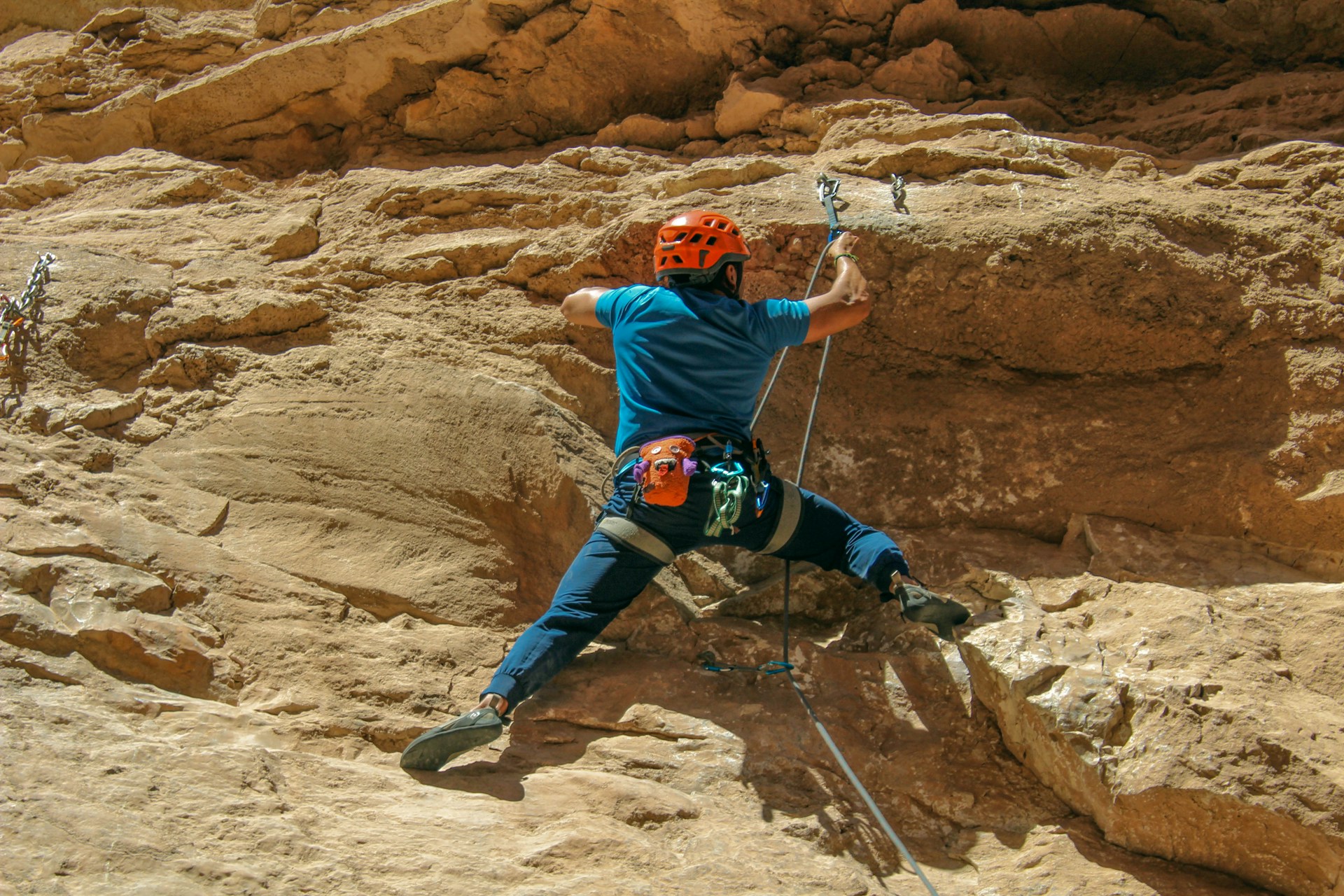 A man climbing up the side of a mountain